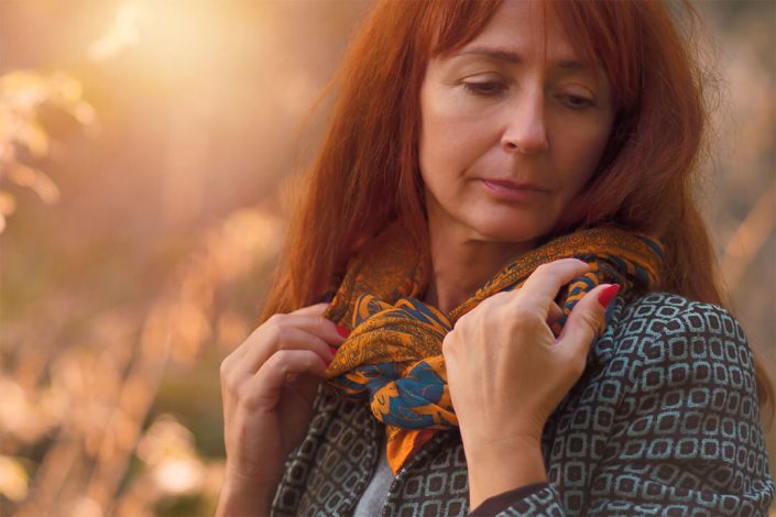 blízky portrét ženy v lese pri západe slnka